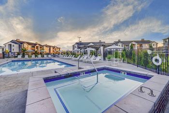 A swimming pool surrounded by a fence and a residential area.